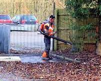 A man blowing leaves